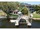 Waterfront property with a large dock, boat lift, and manicured backyard space at 4035 N River View Ave, Tampa, FL 33607