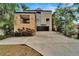 Modern home with a stone accent wall, a dark garage door, and mature landscaping at 4035 N River View Ave, Tampa, FL 33607