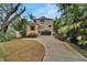 Contemporary two-story home featuring modern architecture, dark garage door, a stone-accented entry, and lush tropical landscaping at 4035 N River View Ave, Tampa, FL 33607
