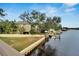 Waterfront home with dock and boat lift, surrounded by lush landscaping and green lawn at 4035 N River View Ave, Tampa, FL 33607