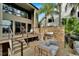 Outdoor entertaining area with a grill, comfortable seating, and steps leading to the waterfront at 4035 N River View Ave, Tampa, FL 33607