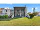 Backyard area featuring a spacious screened lanai, outdoor seating, and lush green lawn at 4358 Outrigger Ln, Tampa, FL 33615
