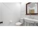 Well-lit bathroom featuring a pedestal sink, tiled shower, and classic fixtures; clean and functional at 4358 Outrigger Ln, Tampa, FL 33615