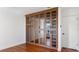 Bedroom with built-in wall closet, hardwood floors, crown molding, and paneled glass doors at 4358 Outrigger Ln, Tampa, FL 33615