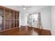 Bedroom featuring hardwood floors, built-in shelving, crown molding, and stylish curtains; the entry to the bathroom is also visible at 4358 Outrigger Ln, Tampa, FL 33615