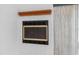 Close-up of a white brick fireplace featuring a black framed firebox and a wooden mantel at 4358 Outrigger Ln, Tampa, FL 33615