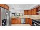 Spacious kitchen featuring stainless steel appliances, tiled backsplash and warm wood cabinetry at 4358 Outrigger Ln, Tampa, FL 33615