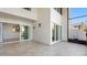 Spacious covered patio featuring travertine flooring and sliding glass doors leading to indoor dining and kitchen areas at 4358 Outrigger Ln, Tampa, FL 33615