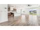 Bright living room featuring wood look tile flooring that complements an open floor plan with kitchen access at 4417 Hollow Stump Run, Palmetto, FL 34221