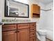 Bathroom with wooden vanity, granite countertop, framed mirror, toilet, and a tiled bathtub-shower combination at 500 Hillpine Way, Brandon, FL 33510