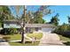 This split-level home boasts a manicured lawn, lovely walkway, attached two car garage, and mature trees at 500 Hillpine Way, Brandon, FL 33510