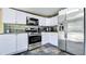 Modern kitchen with white cabinets, stainless steel appliances, and tiled backsplash at 500 Hillpine Way, Brandon, FL 33510