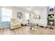 Cozy living room featuring a white leather sectional sofa, armchair, modern lighting, and decorative art at 500 Hillpine Way, Brandon, FL 33510