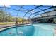This pool area is screened-in with water views, complemented by patio seating and mature greenery at 500 Hillpine Way, Brandon, FL 33510