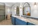 Well-lit bathroom with double sink vanity, decorative mirrors and glass enclosed shower at 5024 W Homer Ave, Tampa, FL 33629