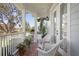 Inviting front porch with brick floor, white wicker chairs, and lush potted plants at 5024 W Homer Ave, Tampa, FL 33629