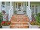 Close up of front porch showing brick steps, white rails, planters and a decorative frog at 5024 W Homer Ave, Tampa, FL 33629