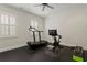 Home gym featuring a treadmill, exercise bike, rubber floor, ceiling fan and bright natural light at 5024 W Homer Ave, Tampa, FL 33629