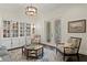 Bright living room with decorative armchairs, a modern light fixture, and French doors to the patio at 5024 W Homer Ave, Tampa, FL 33629
