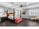 Spacious main bedroom featuring a tray ceiling, dark wood floors, and a four-poster bed at 5024 W Homer Ave, Tampa, FL 33629