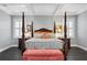 Nicely decorated main bedroom featuring a tray ceiling, and a four-poster bed with dark wood floors at 5024 W Homer Ave, Tampa, FL 33629