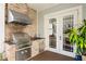 Outdoor kitchen featuring a grill, sink, and brick facade, perfect for outdoor entertaining at 5024 W Homer Ave, Tampa, FL 33629