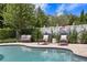 A backyard pool with a jacuzzi, elegant lounge seating and a well-manicured yard and privacy fence at 5024 W Homer Ave, Tampa, FL 33629