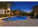 Stunning backyard pool with a central jacuzzi, lounge chairs, and exterior lights illuminating the outdoor space at 5024 W Homer Ave, Tampa, FL 33629