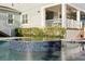 A modern in-ground spa with blue tile work is attached to a beautiful in-ground pool on a stone patio at 5024 W Homer Ave, Tampa, FL 33629