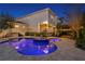 Back exterior view of a house with a spacious pool, jacuzzi, manicured landscaping, and a covered patio with lights at 5024 W Homer Ave, Tampa, FL 33629
