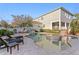 Backyard pool featuring a spillover spa, surrounded by a well-maintained patio and a view of the home's exterior at 5024 W Homer Ave, Tampa, FL 33629