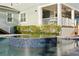 Close up of a jacuzzi in the corner of a backyard pool with stone pavers and a view of the house's exterior at 5024 W Homer Ave, Tampa, FL 33629