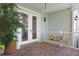 Relaxing side porch with brick floor, a swing, and French doors that lead into the home at 5024 W Homer Ave, Tampa, FL 33629