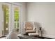 Cozy sitting area with tufted chair, ottoman and a view of the outdoor balcony at 5024 W Homer Ave, Tampa, FL 33629