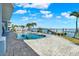 Backyard view with a pool, dock, and picturesque waterfront, perfect for outdoor entertaining and relaxation at 535 Johns Pass Ave, Madeira Beach, FL 33708