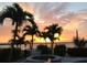 Scenic waterfront with palm trees silhouetted against a colorful sunset, creating a tranquil tropical atmosphere at 535 Johns Pass Ave, Madeira Beach, FL 33708