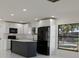 Stylish kitchen with a dark island, white cabinets, and modern black appliances at 6125 Liberty Ave, Temple Terrace, FL 33617