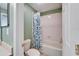 This bathroom features white tile walls, a shower-tub combo, and a decorative shower curtain at 6308 Bridgevista Dr, Lithia, FL 33547
