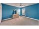 Blue bedroom with neutral carpet, light wood dresser, and window with blinds at 6308 Bridgevista Dr, Lithia, FL 33547