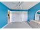 Blue bedroom featuring a ceiling fan, neutral carpet, and three white closets at 6308 Bridgevista Dr, Lithia, FL 33547