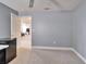 Bonus room featuring neutral carpet, a mini fridge, and a glimpse into the living room, perfect for entertaining at 6308 Bridgevista Dr, Lithia, FL 33547