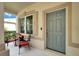 Inviting front porch featuring seating and a stylish gray front door at 6308 Bridgevista Dr, Lithia, FL 33547