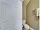 This half bathroom features a toilet, a towel rack and a door for privacy at 6308 Bridgevista Dr, Lithia, FL 33547