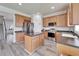 Well-equipped kitchen features stainless steel appliances, an island, and wood cabinets at 6308 Bridgevista Dr, Lithia, FL 33547