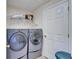 This laundry room features gray washer and dryer units and wire shelving at 6308 Bridgevista Dr, Lithia, FL 33547