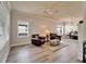 Spacious living room featuring two brown leather chairs, ceiling fan, and ample natural light at 6308 Bridgevista Dr, Lithia, FL 33547