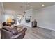 Open floor plan living room with stairs, gray flooring, leather chairs, and a ceiling fan at 6308 Bridgevista Dr, Lithia, FL 33547