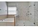 The main bathroom features a walk-in shower with a glass door, a soaking tub and a window at 6308 Bridgevista Dr, Lithia, FL 33547