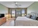 This main bedroom features wood-look floors, a ceiling fan, 2 windows with curtains and room for furnishings at 6308 Bridgevista Dr, Lithia, FL 33547