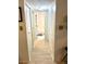 Hallway with white wood-look flooring, and linen closets leading to the bathroom with white tub/shower at 6826 Stones Throw N Cir # 11305, St Petersburg, FL 33710